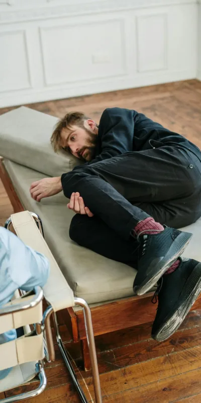 Man in Black Long Sleeve Shirt Lying on Gray Couch
