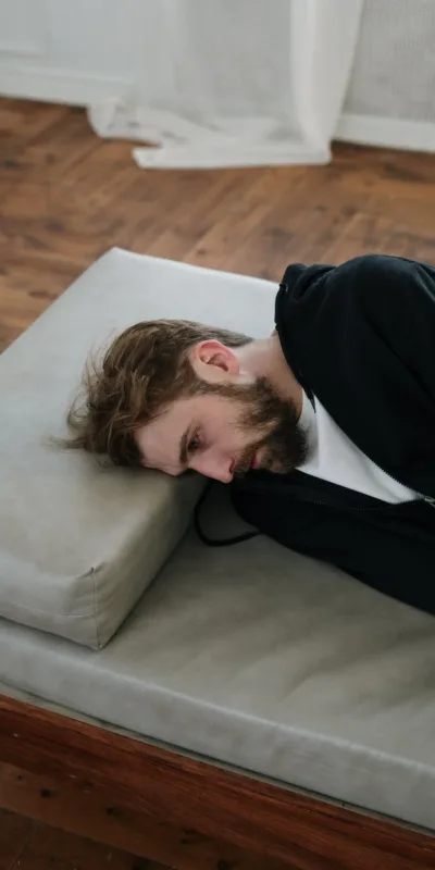 Man in Black Long Sleeve Shirt Lying on Gray Couch