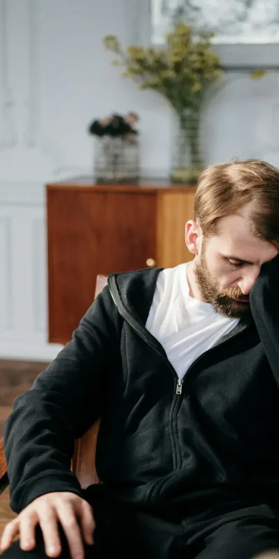 Man in Black Zip Up Jacket Sitting on Chair